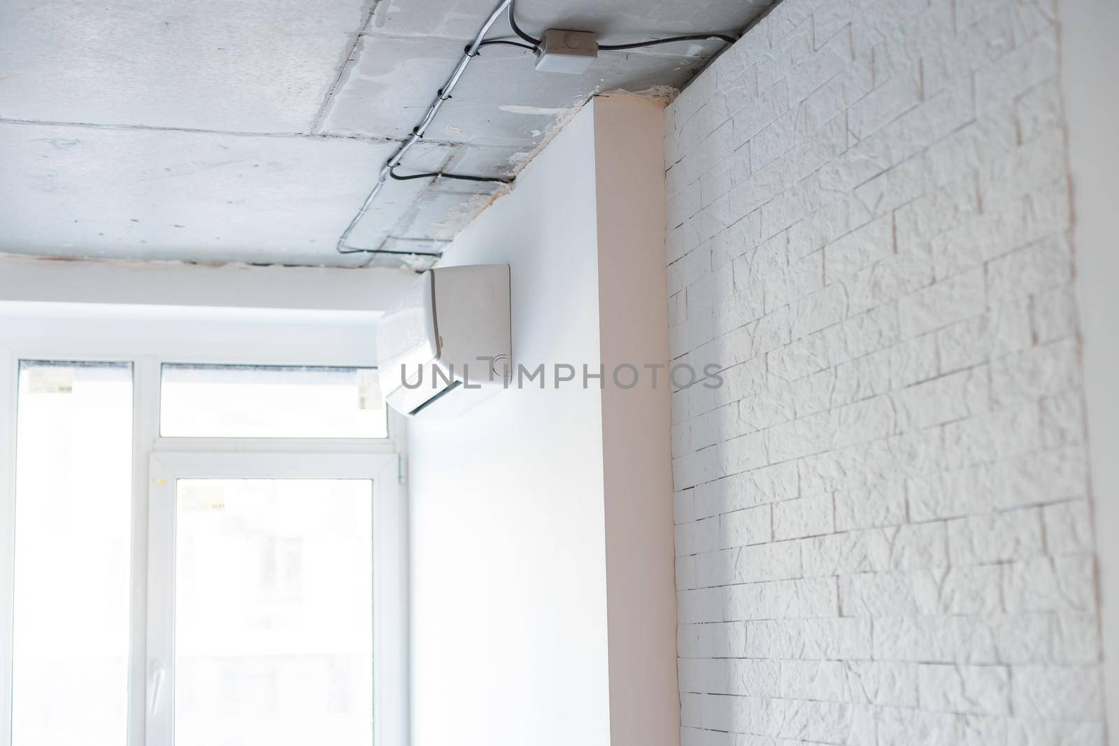 shot of newly installed white air conditioner. Working AC hanging on the pastel color wall with a lot of copy space for text. Background. by Andelov13