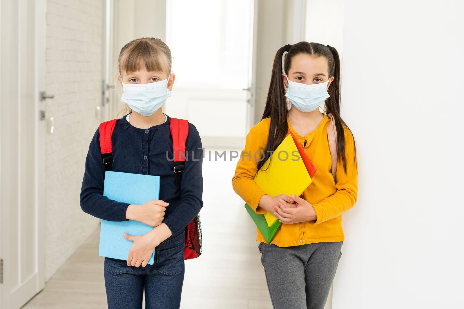 Two pupils friends in protective masks with backpacks. day at school concept.