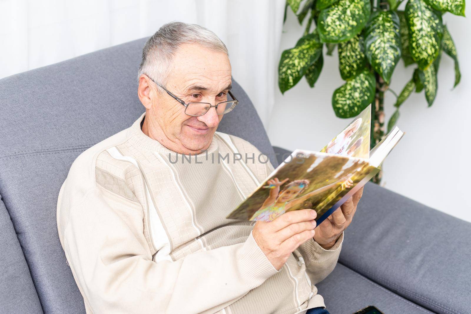 An old man in a hospital ward watching photobook by Andelov13