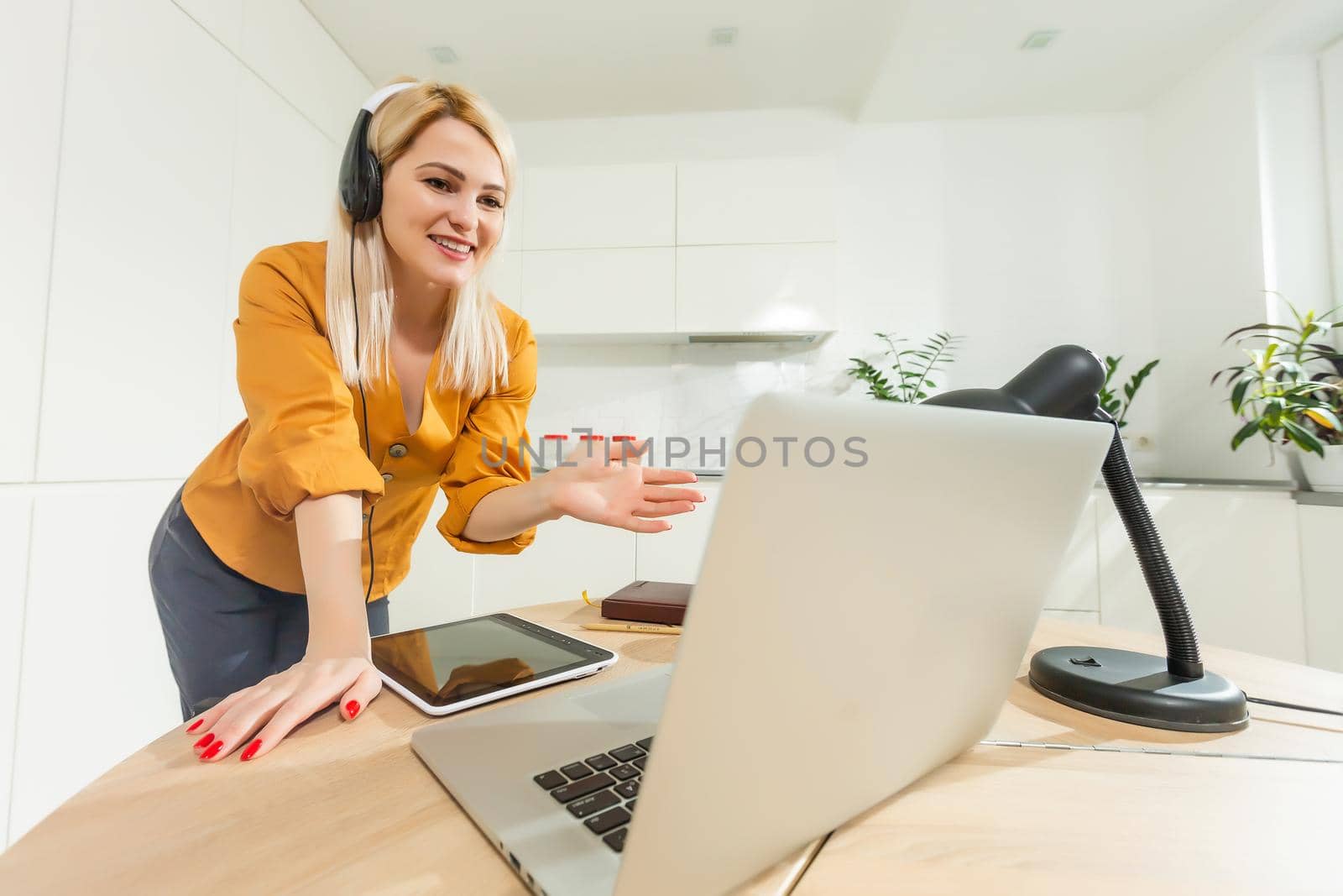 Beautiful caucasian woman working on laptop. Kitchen background.