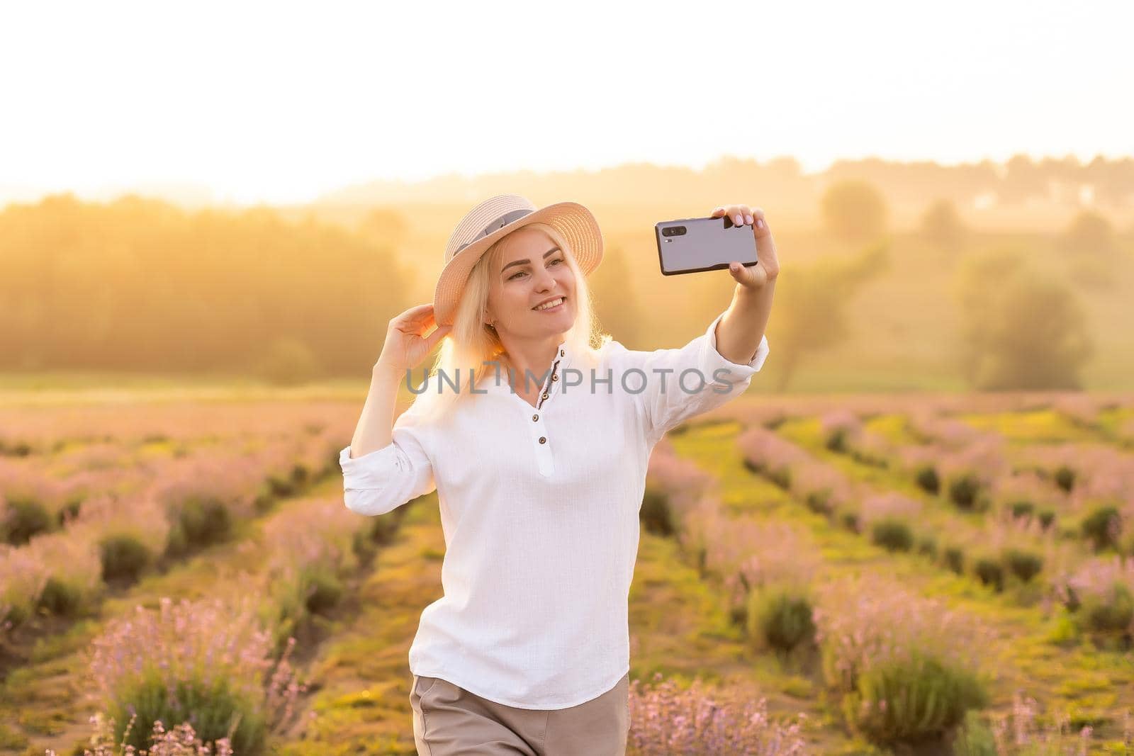 woman taking photo with mobile cell phone in the lavender field.