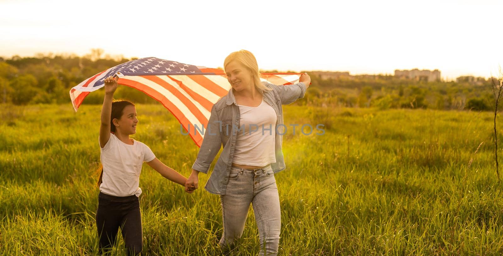 happy mother and daughter with american flag outside by Andelov13