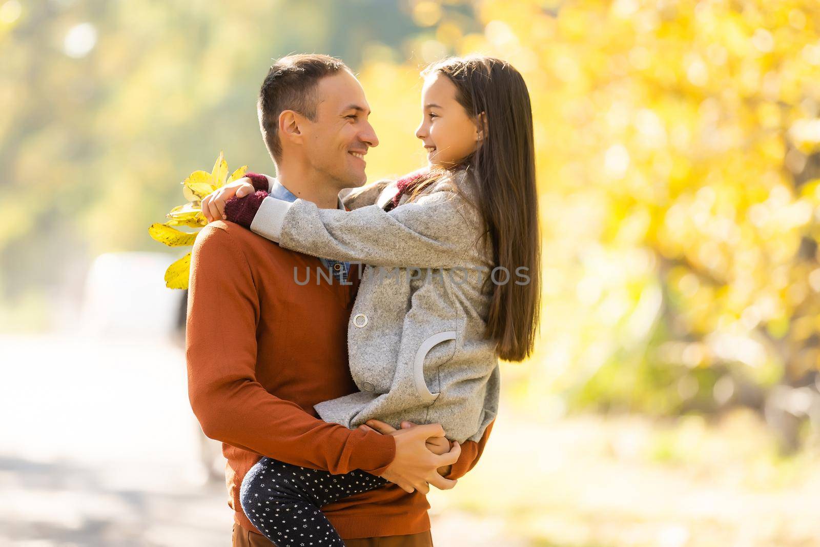 Happy father with daughter in fall season.