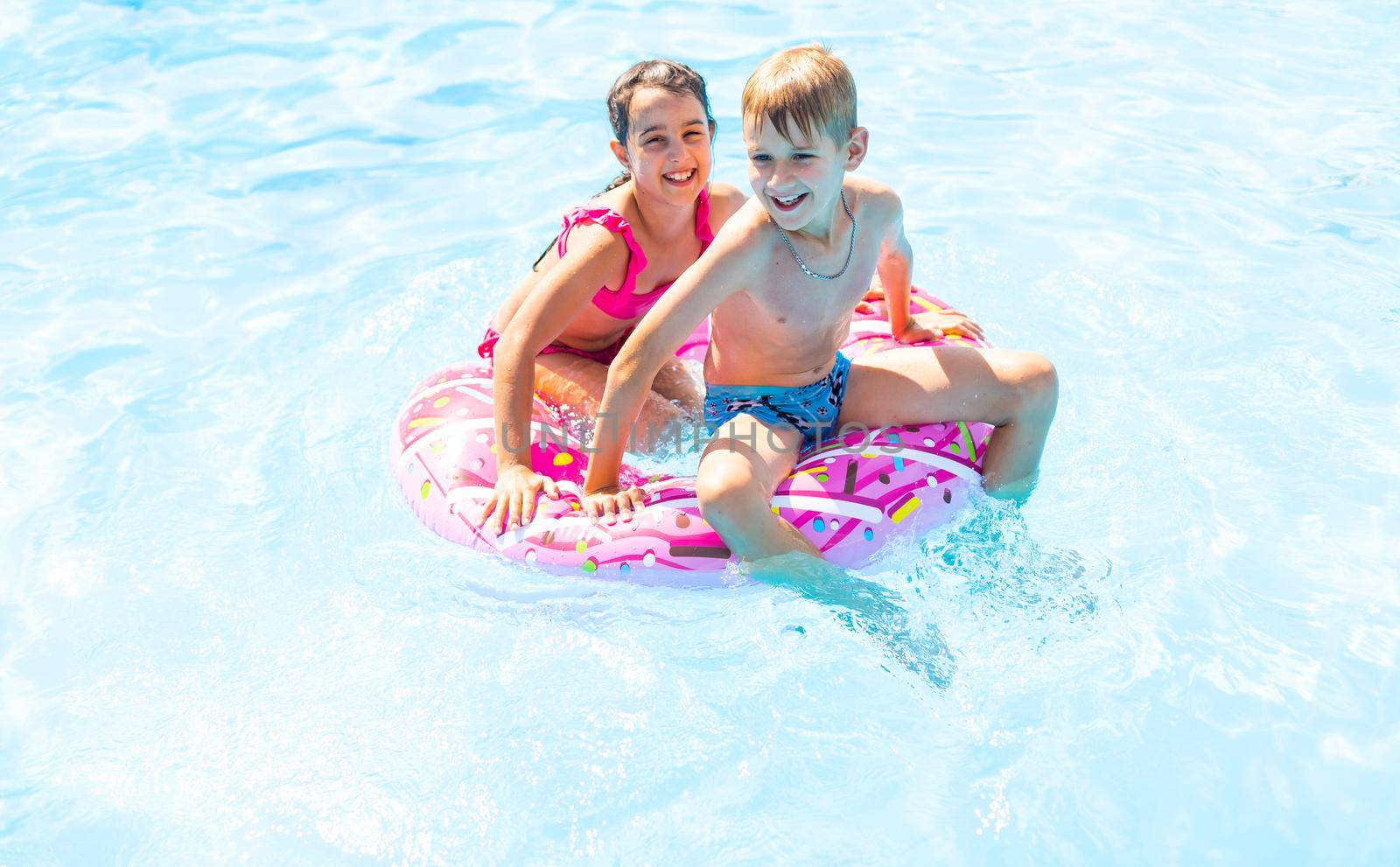 Happy friends jumping in pool on the vacations.