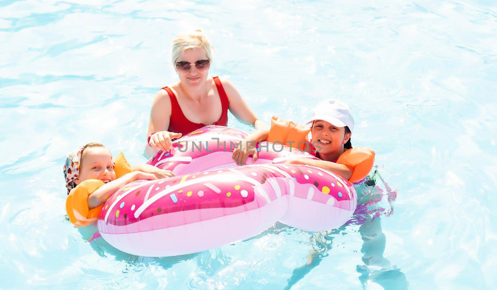 Happy family playing in swimming pool. Summer vacation concept.