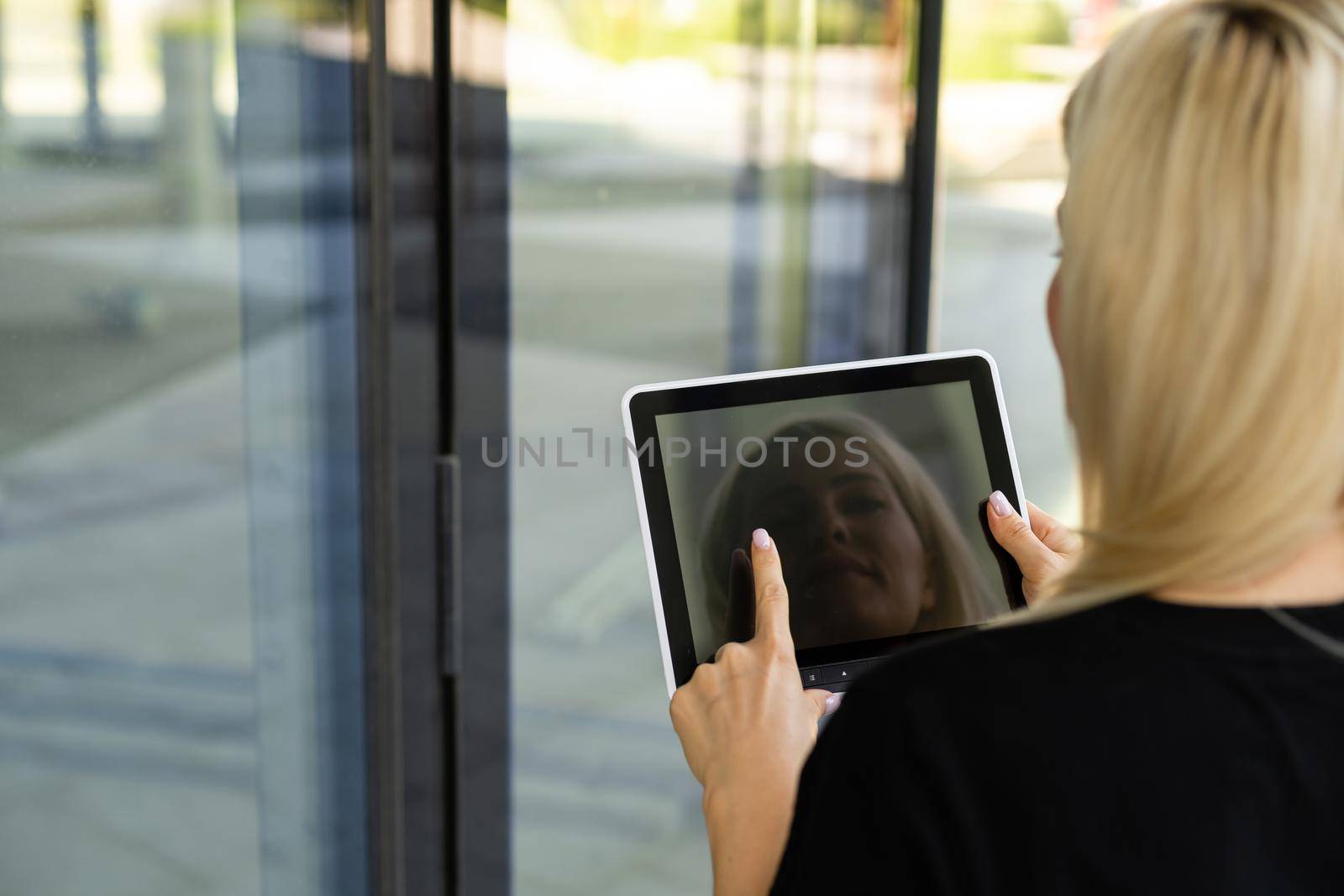 Portrait of a successful woman using digital tablet during quick break in front a corporate building