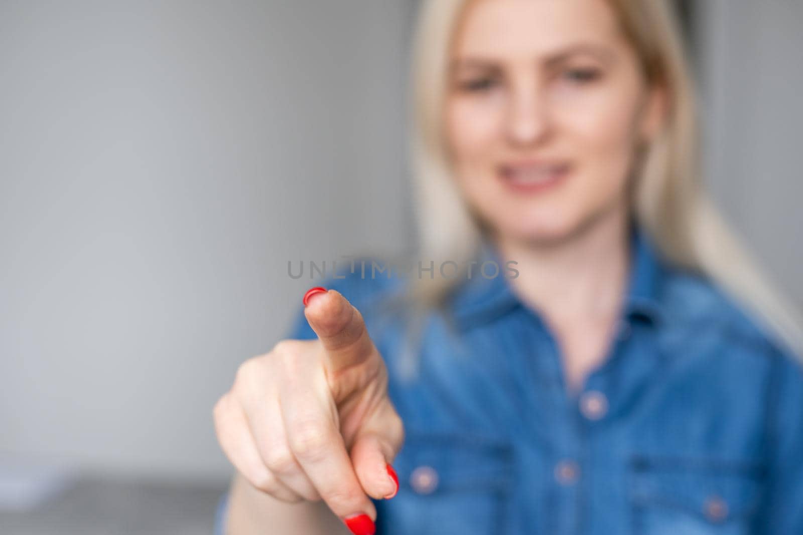 Woman touching an imaginary screen with her finger - isolated.