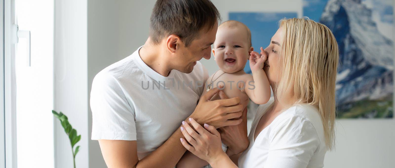 A Happy young family with baby in white bedroom by Andelov13