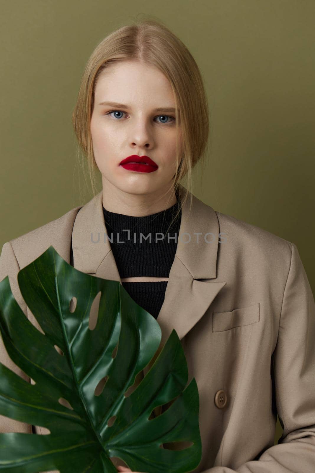 portrait of a woman in coat red lips fashion palm leaf Lifestyle posing. High quality photo