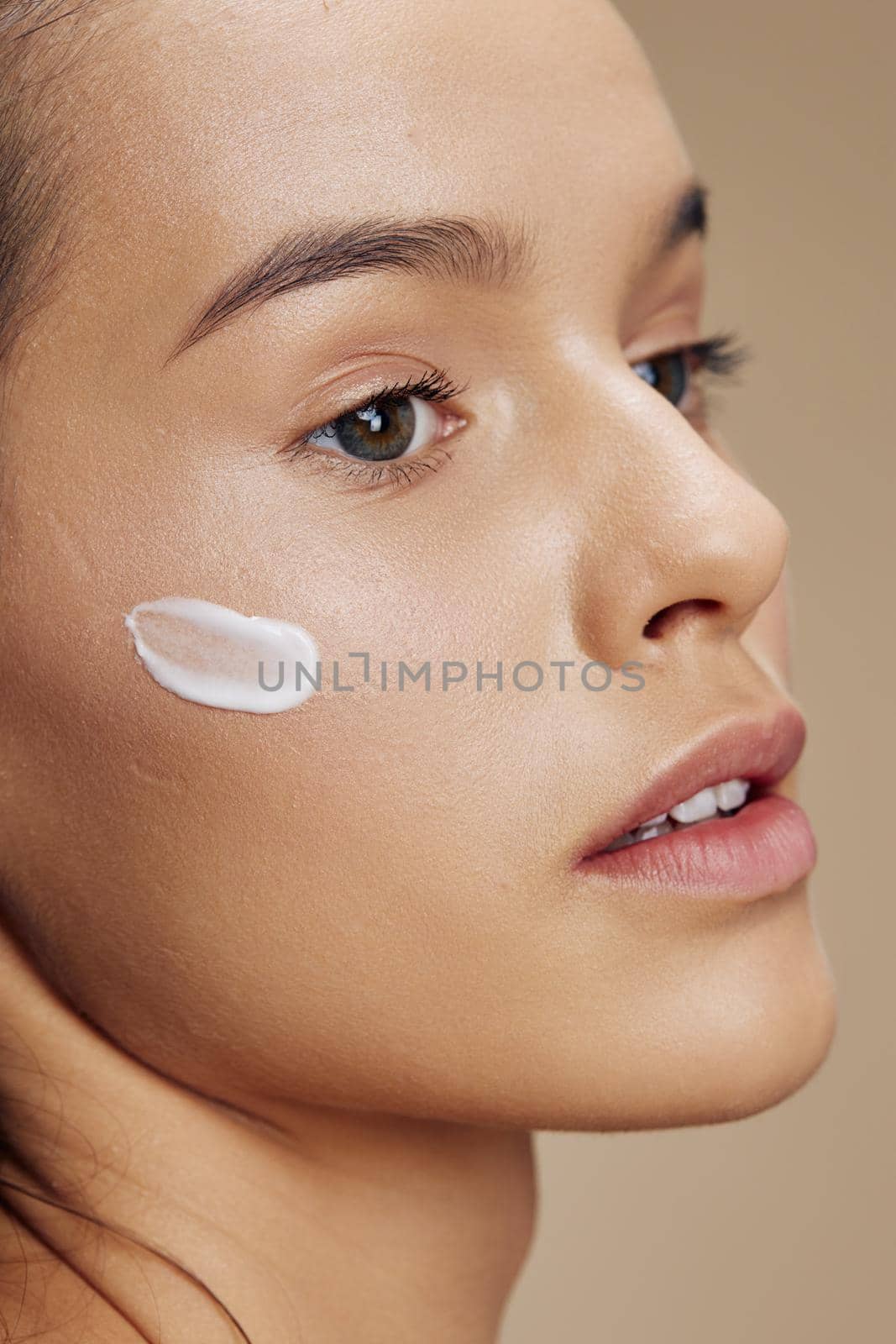 beautiful woman cream on cheek posing cosmetics to clean skin isolated background by SHOTPRIME