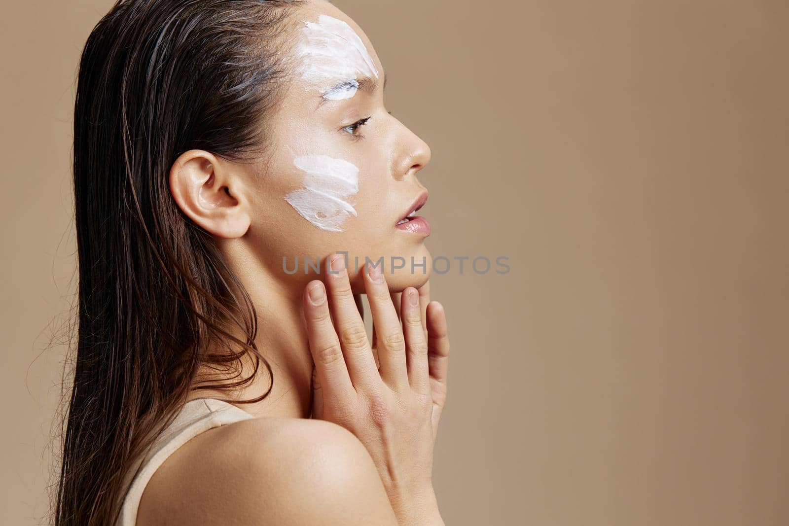 young woman applying a soothing face mask cosmetic close-up make-up. High quality photo