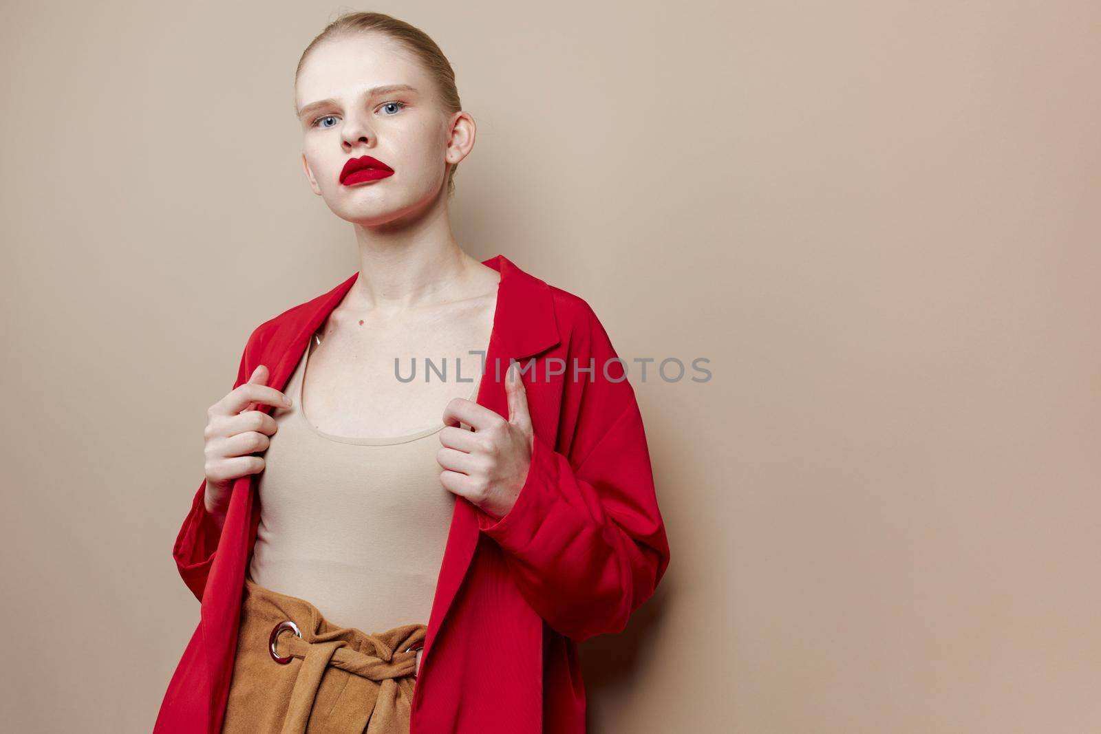 glamorous woman red lips fashion jacket beige background. High quality photo
