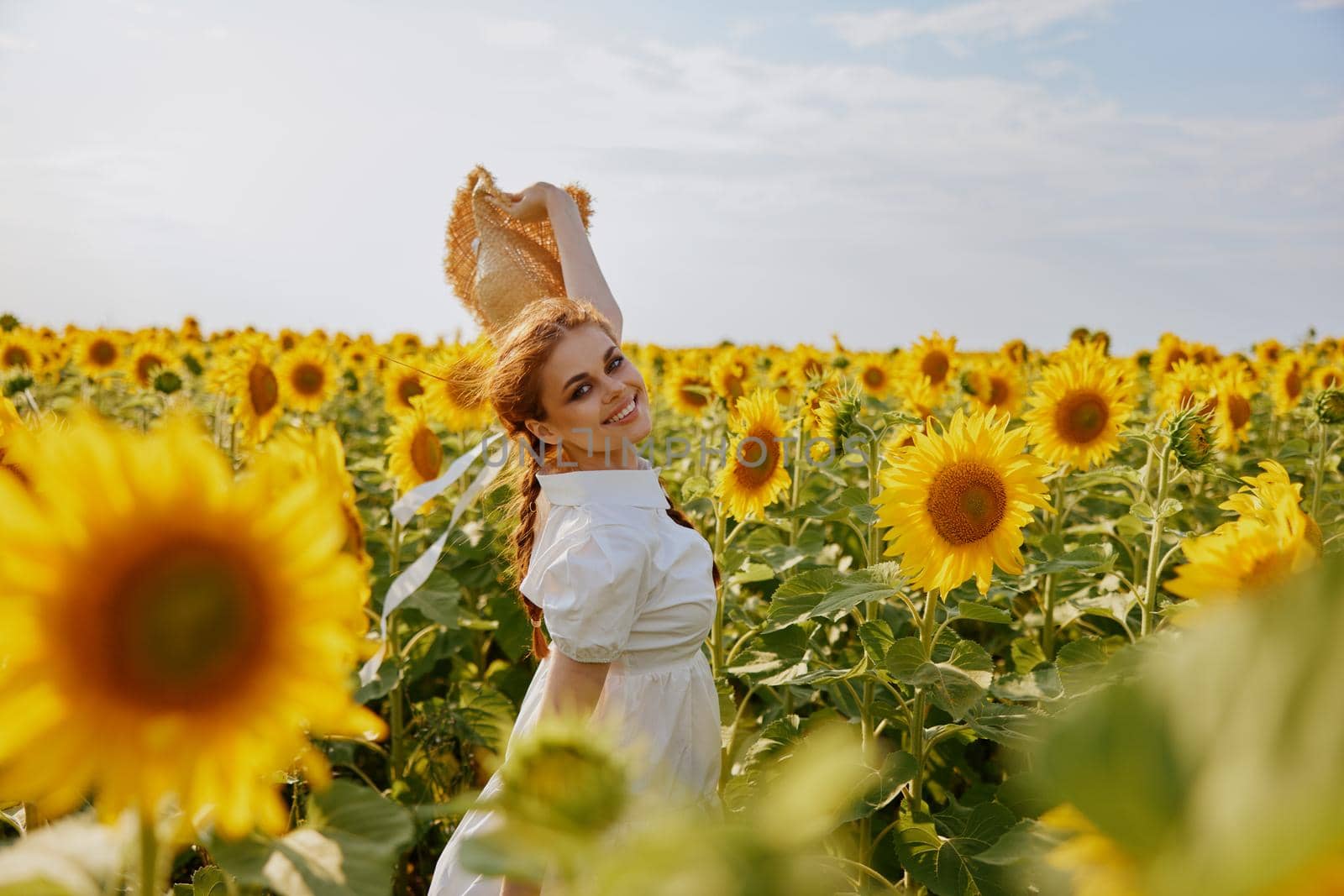 smiling woman in sunflower field hat in hands nature landscape. High quality photo