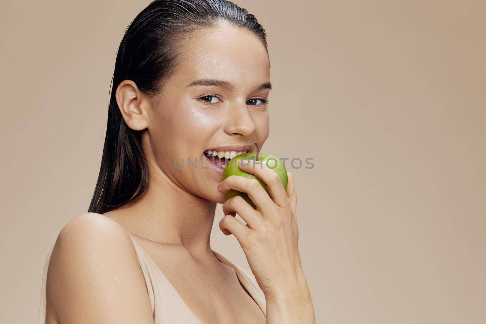portrait young charming brunette woman biting green apple. High quality photo