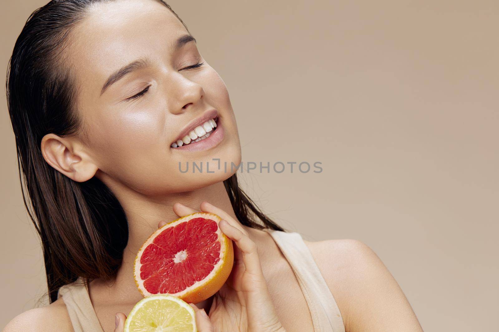 brunette grapefruit near face clean skin care health isolated background. High quality photo