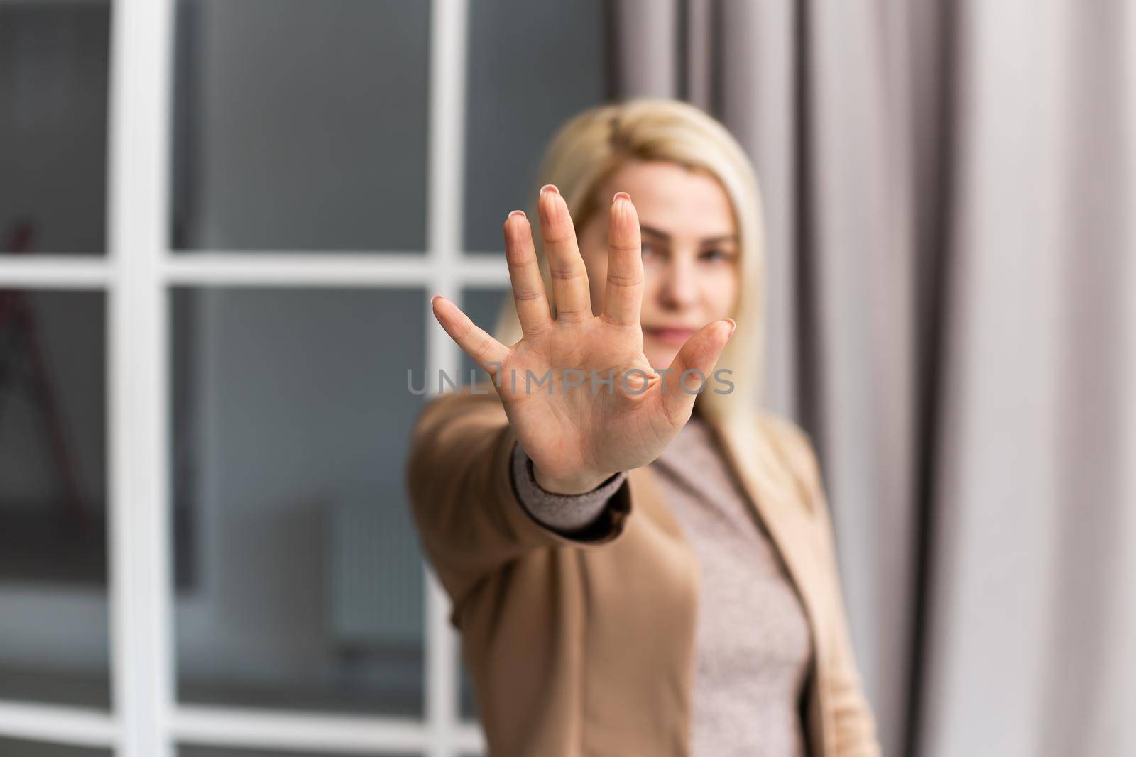 Portrait of young woman making stop sign with her hand