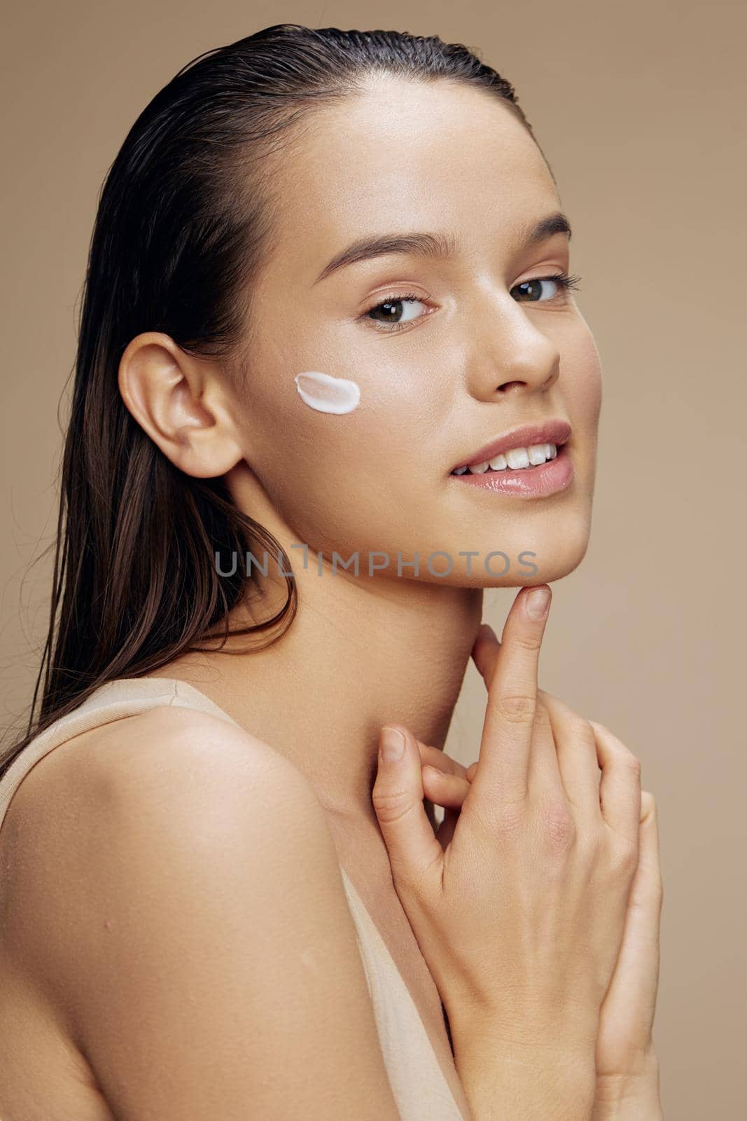 smiling young woman applying a soothing face mask cosmetic isolated background. High quality photo