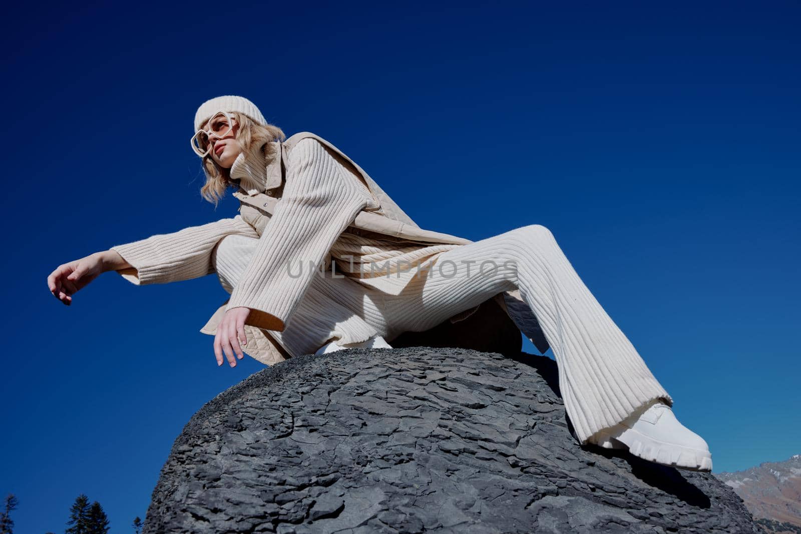 tourist in autumn clothes stands on a rock landscape blue sky relaxation. High quality photo