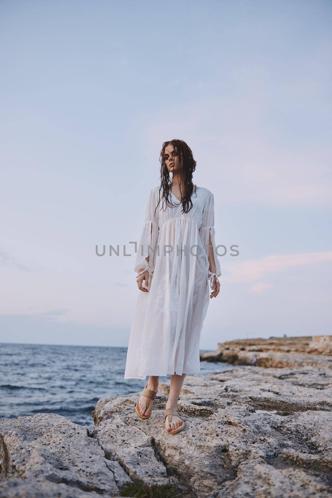 pretty woman in white robe landscape ocean rocks nature unaltered. High quality photo