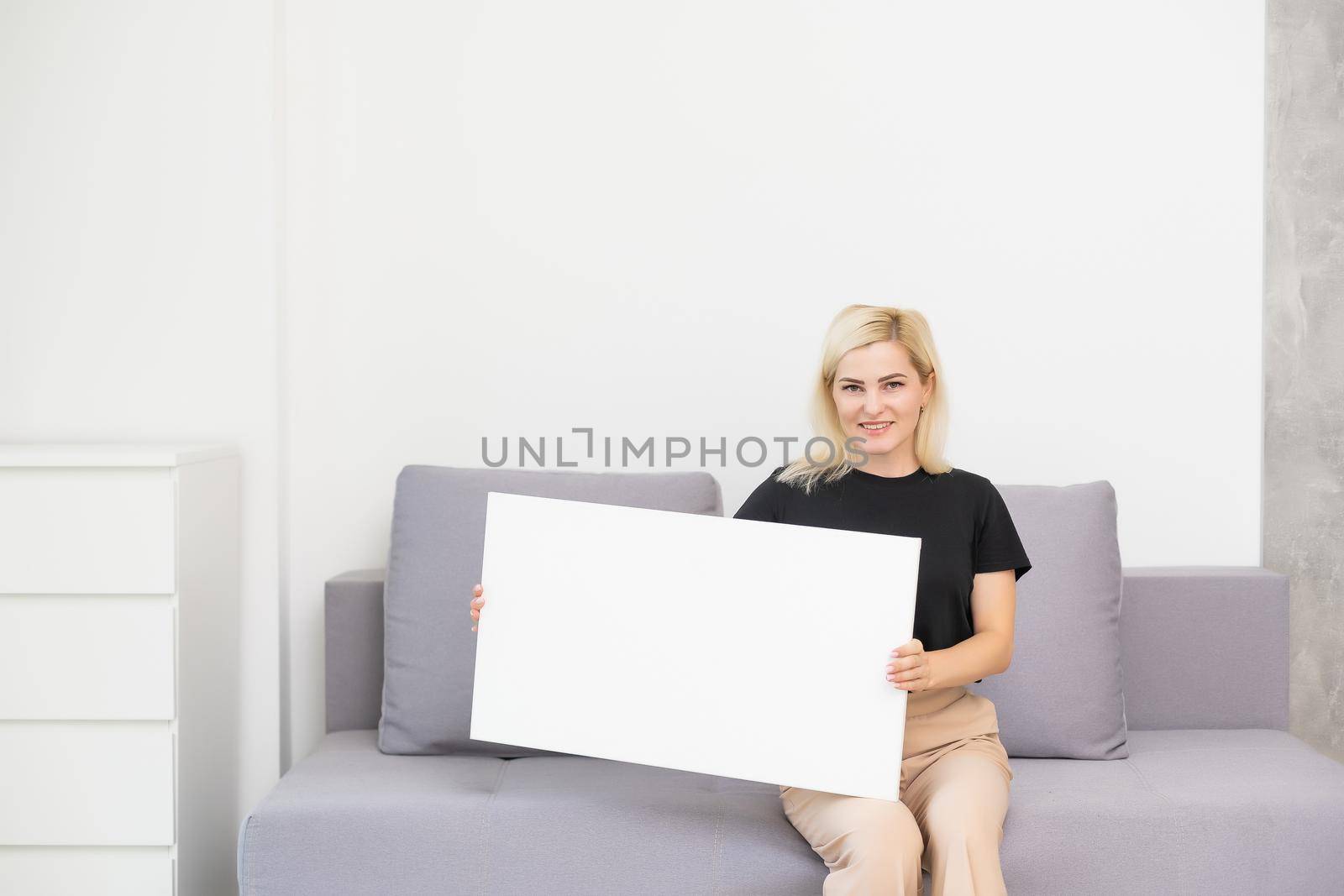 woman looking at the blank white canvas. Horizontal, mockup.