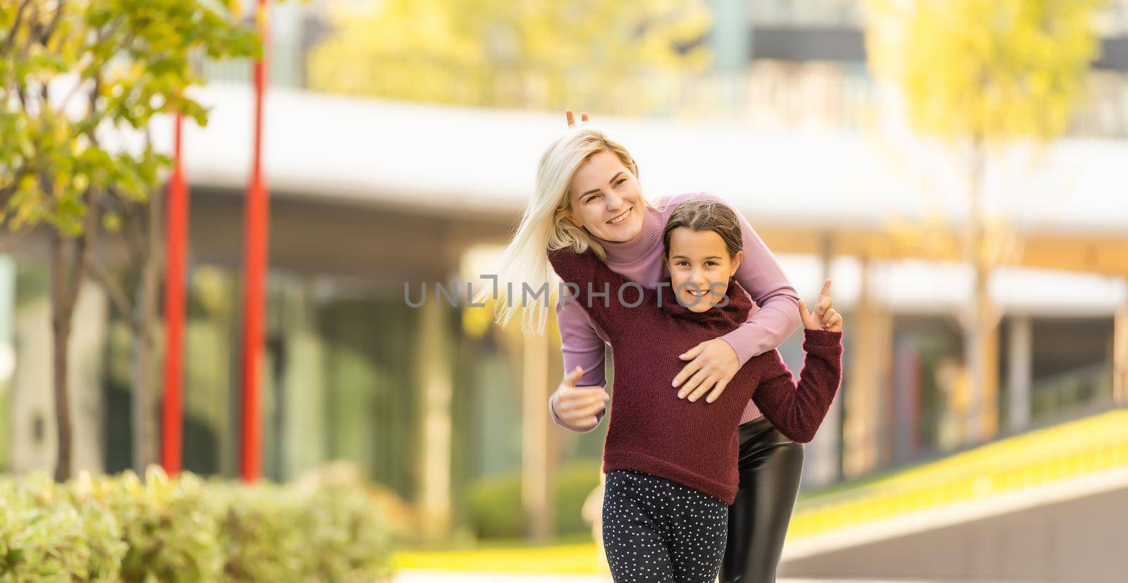 happy family: mother and child little daughter play on autumn walk in nature outdoors.