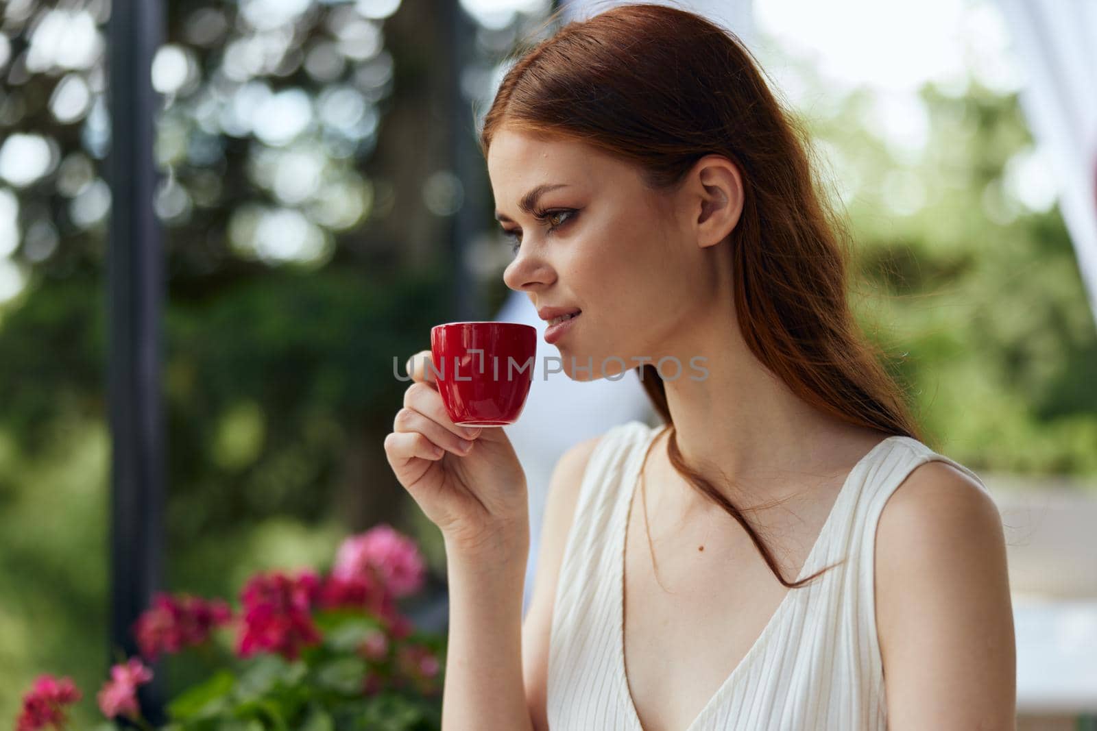 cheerful woman holding a coffee cup standing in the park at summer Happy female relaxing by SHOTPRIME