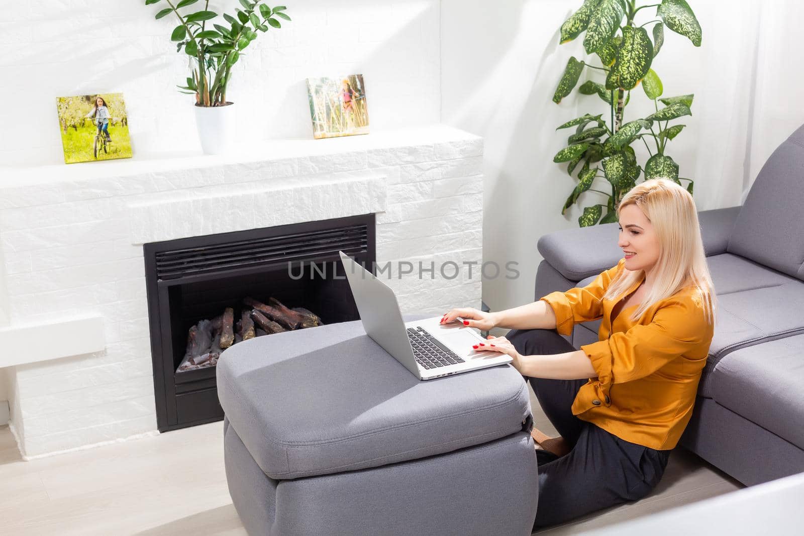 Woman using laptop and working from home by Andelov13