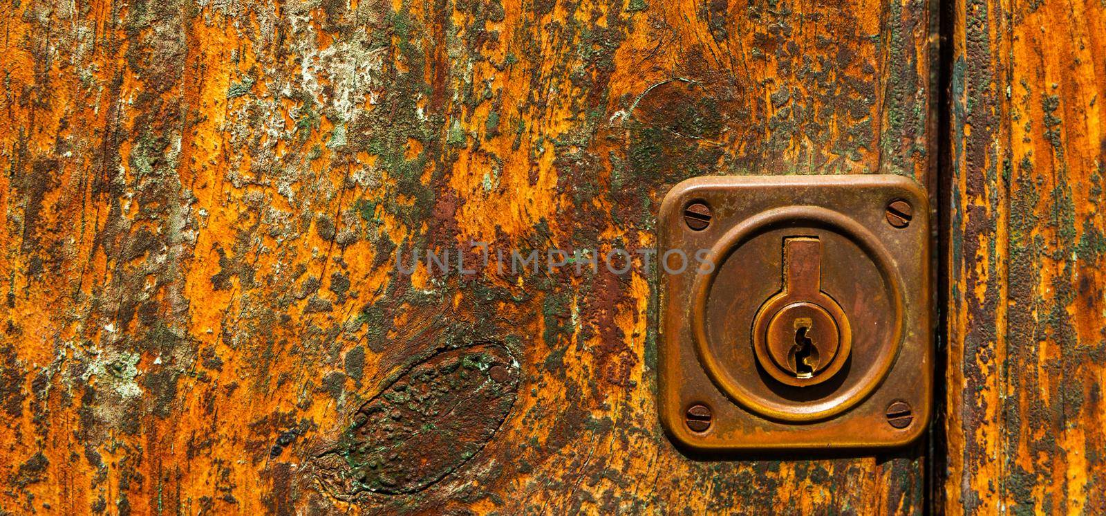close up on the old lock with an interesting texture on the door, home security by Q77photo