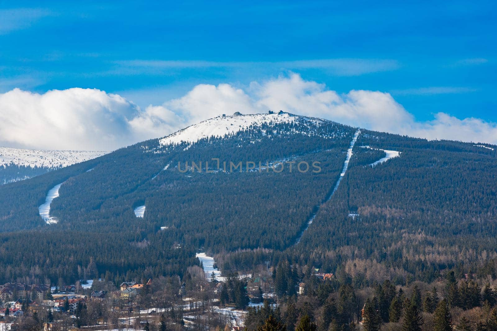 Foggy cloudy landscape seen from long distance of mountain ranges full of snow and giant clouds over it by Wierzchu