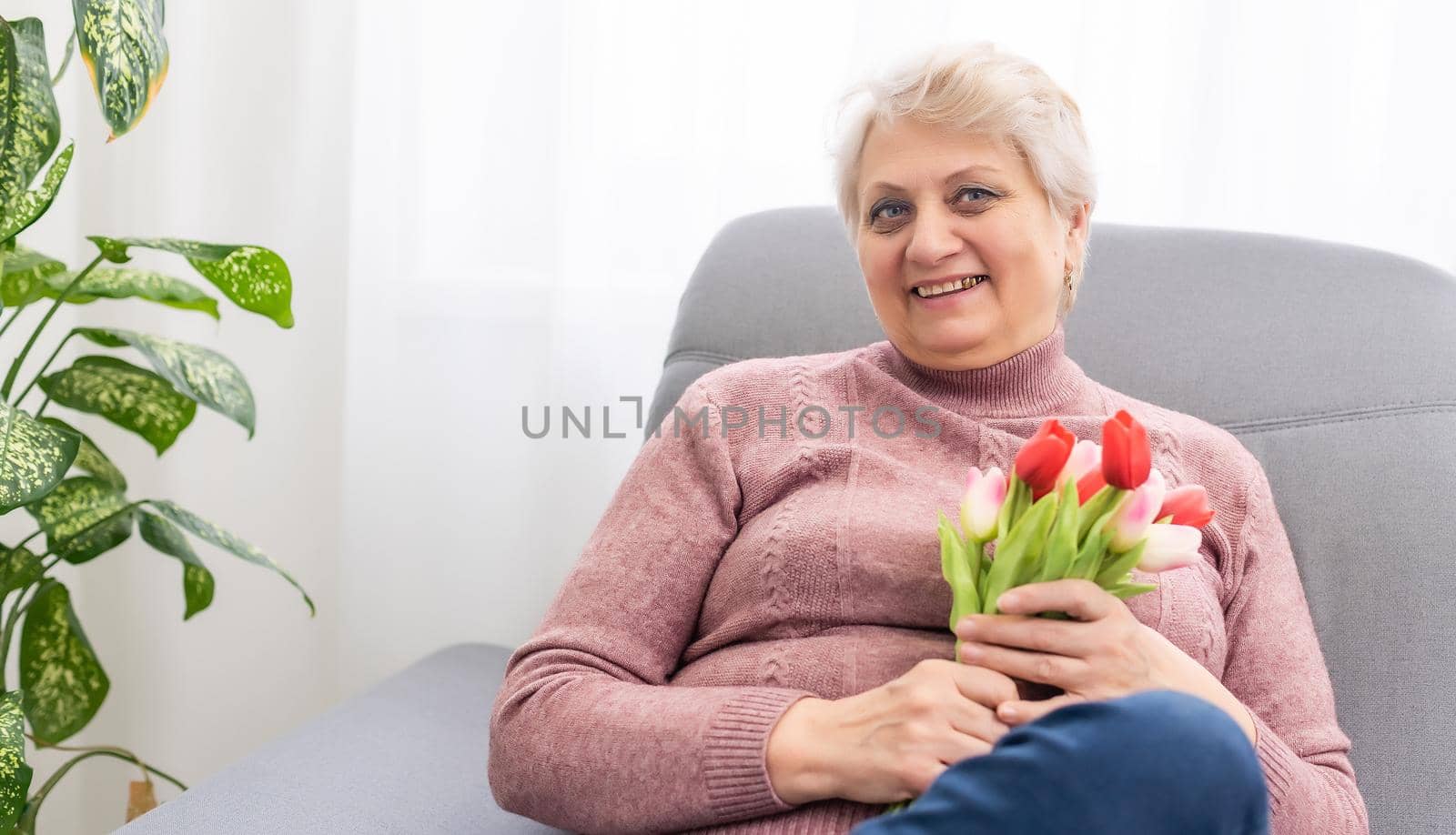 A beautiful old lady smelling a bouquet of tulips by Andelov13
