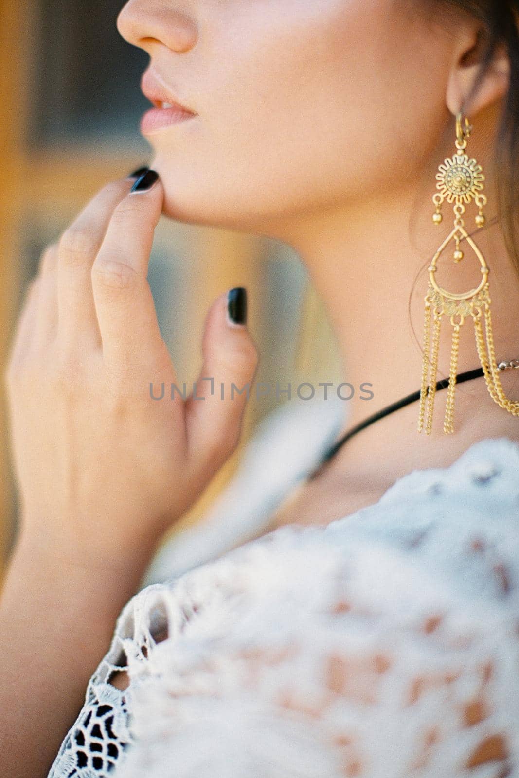 Young woman touches her chin with her fingers. Close-up. High quality photo