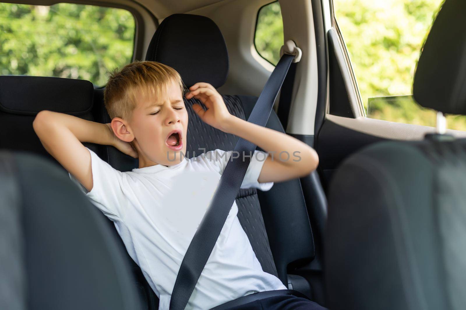 Little blond kid boy in the car.