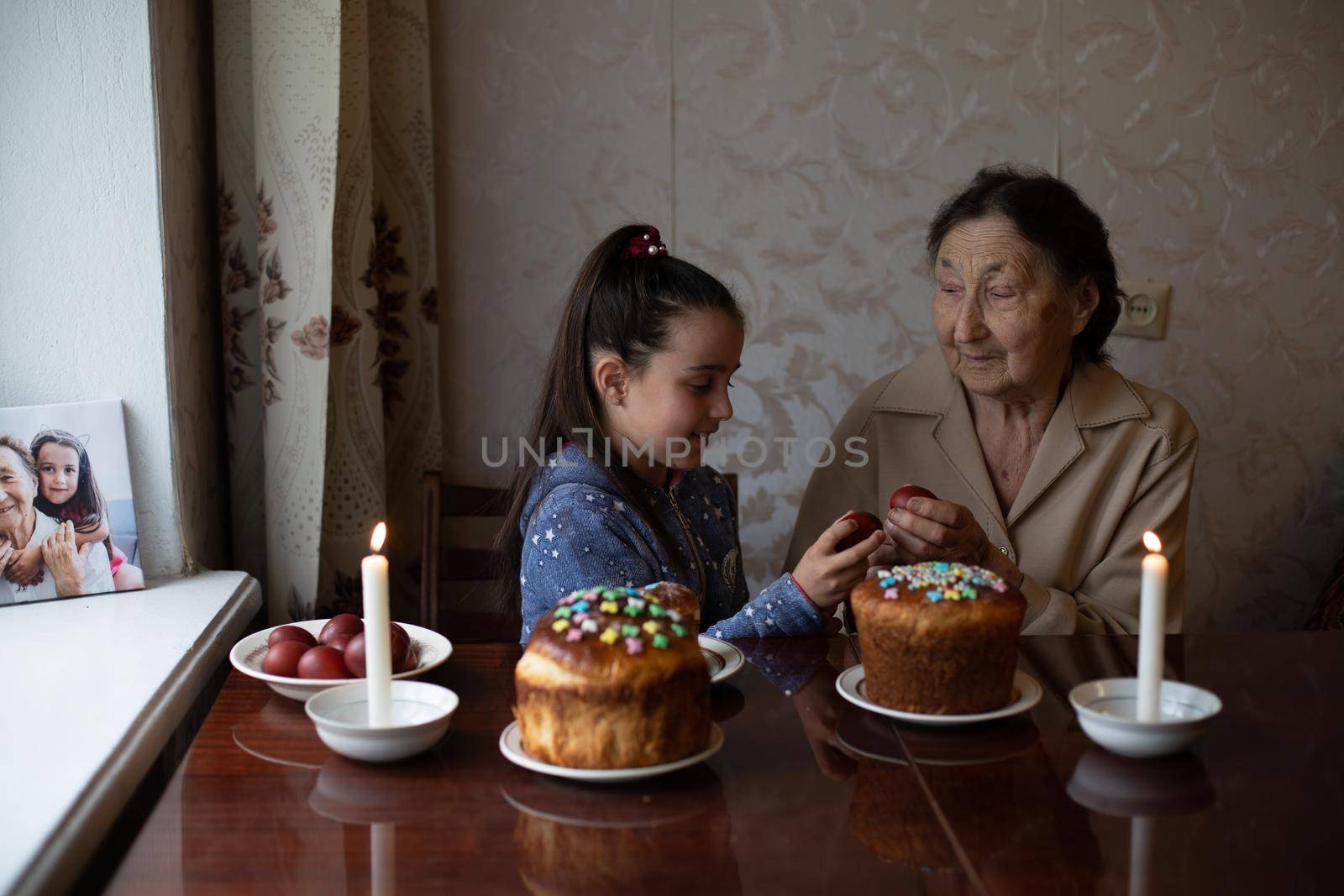 senior woman with easter eggs and Easter cake.