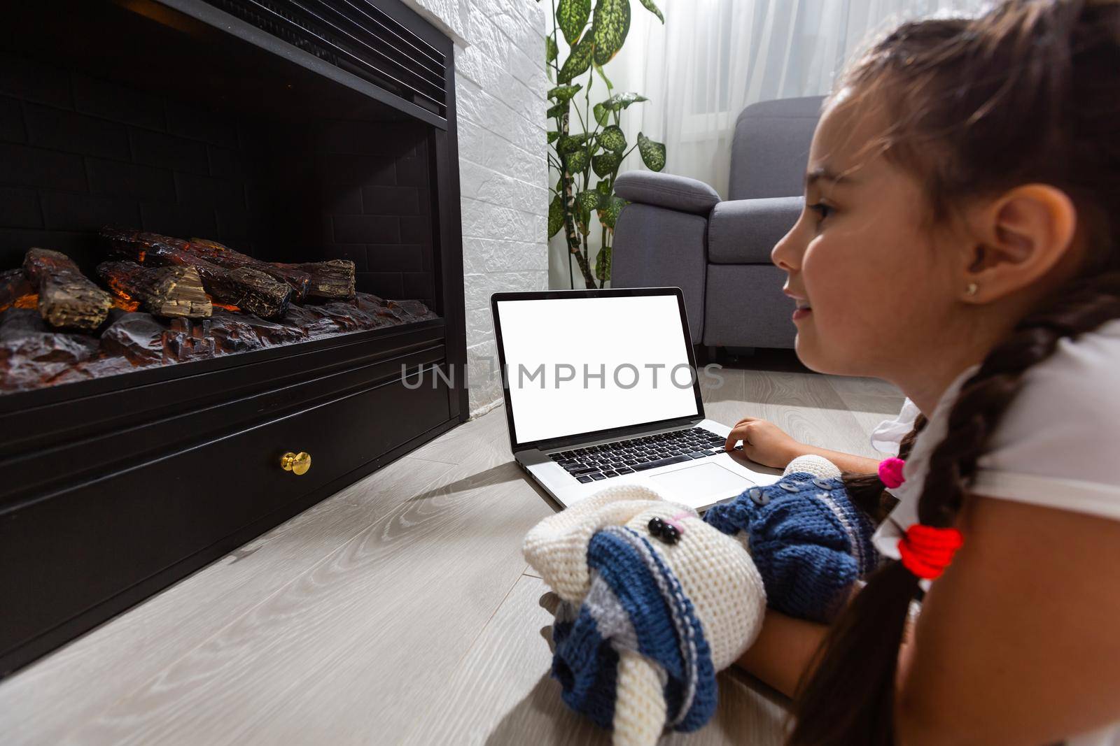 Photo of small pretty overjoyed pupil school girl notebook online lesson video call listen good news nice semester grades best student distance quarantine study comfort room indoors