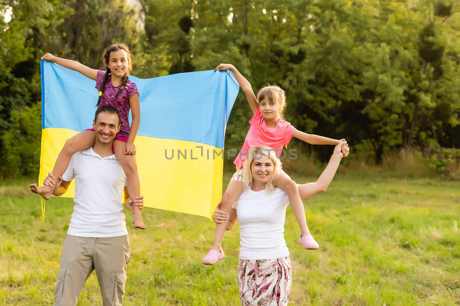 Happy family s with flag of Ukraine in field. by Andelov13