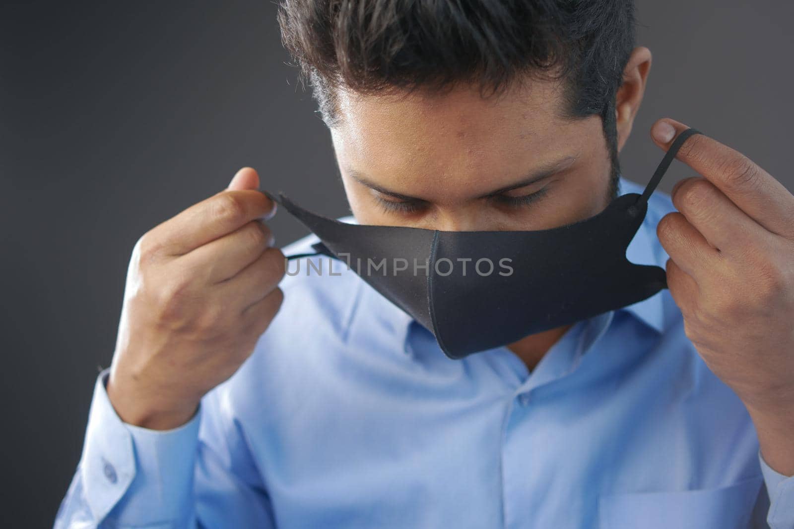 Close up of man with protective face mask looking at camera.