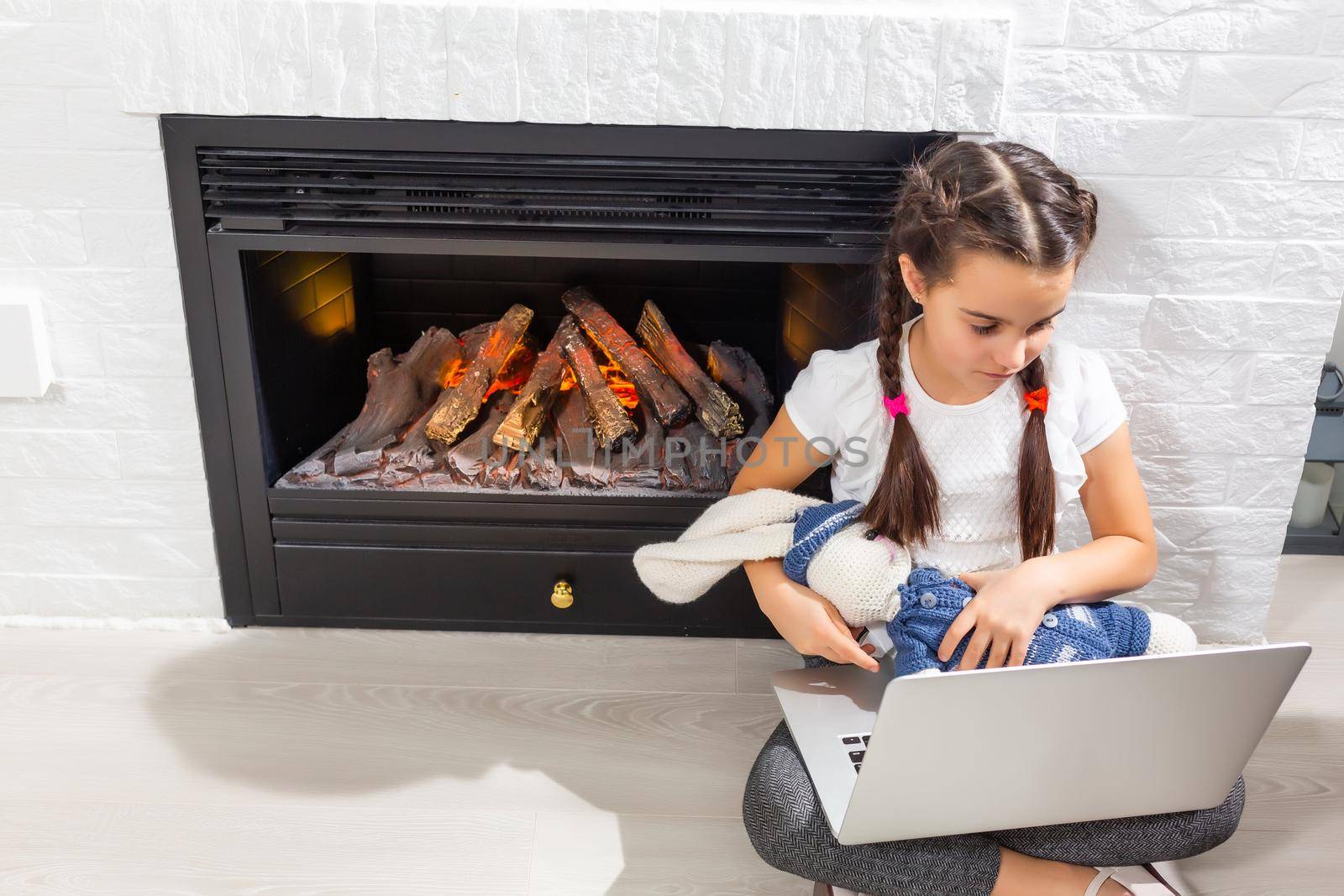 Photo of positive kid girl study remote use laptop have online communication lesson with tutor writing report in house indoors