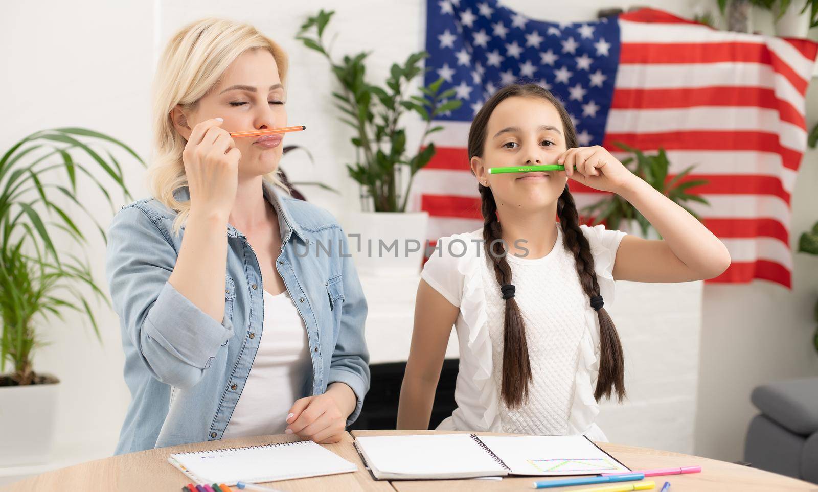 Patriotic holiday. Happy family, mother and her daughter child girl with American flag at home. USA celebrate 4th of July