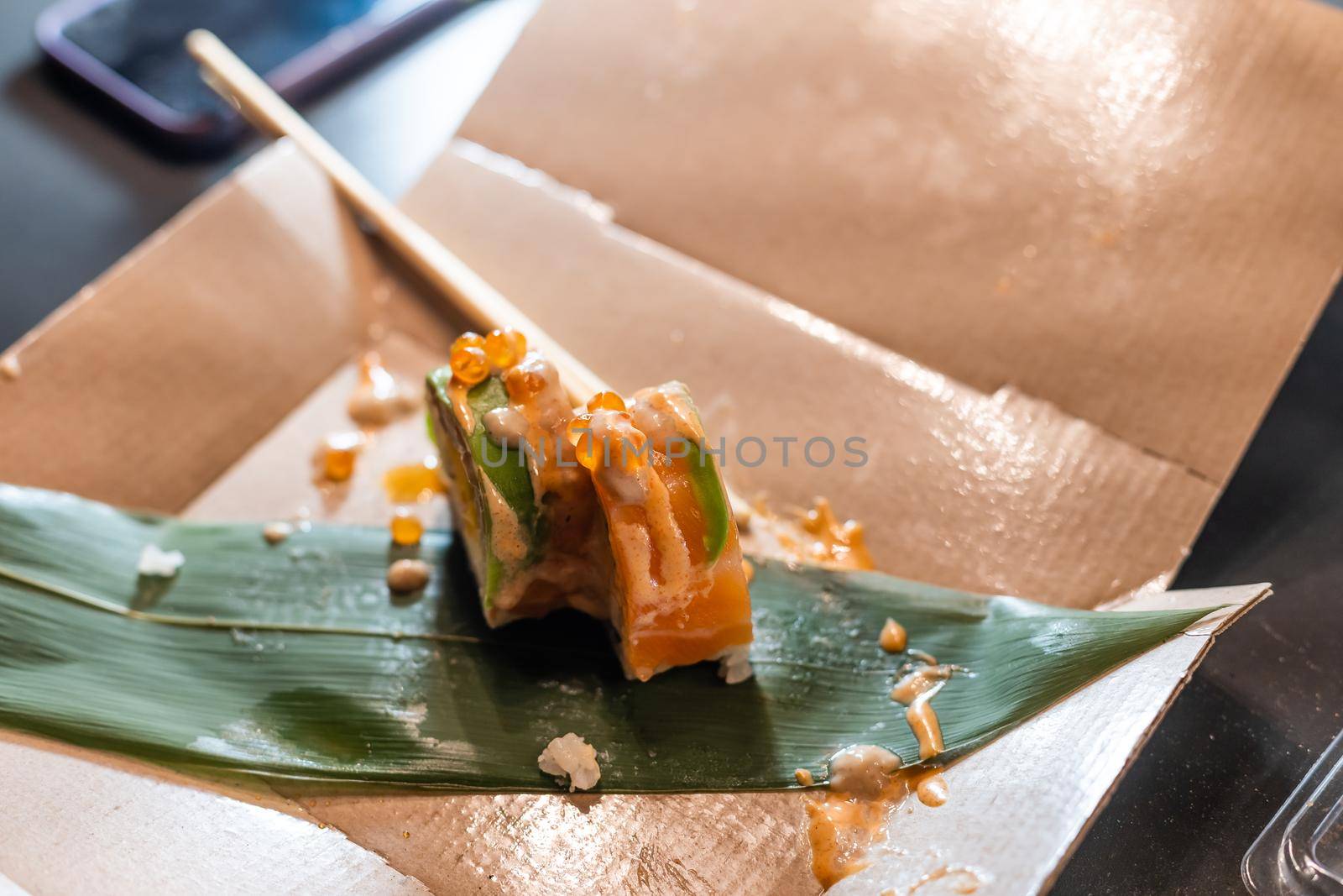 Woman eating sushi rolls at the table - close up photo. Traditional Japanese oriental kitchen with raw fish.