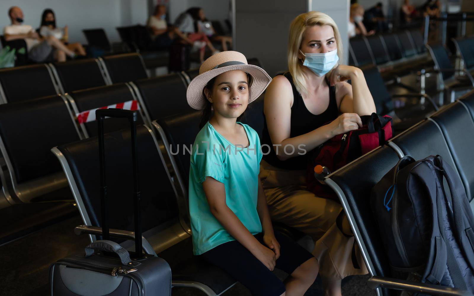Mother and daughter with face mask going on holiday, at the airport by Andelov13