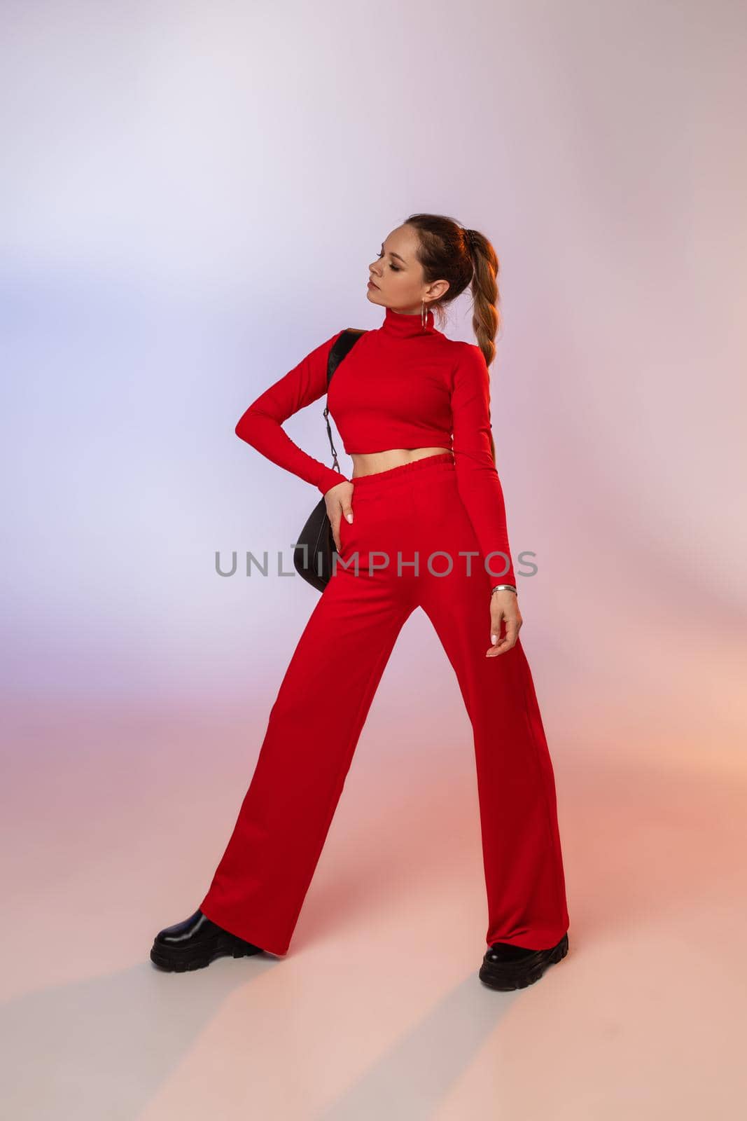 beautiful young woman with pretty face poses for the camera in fashionable red outfit by StudioLucky