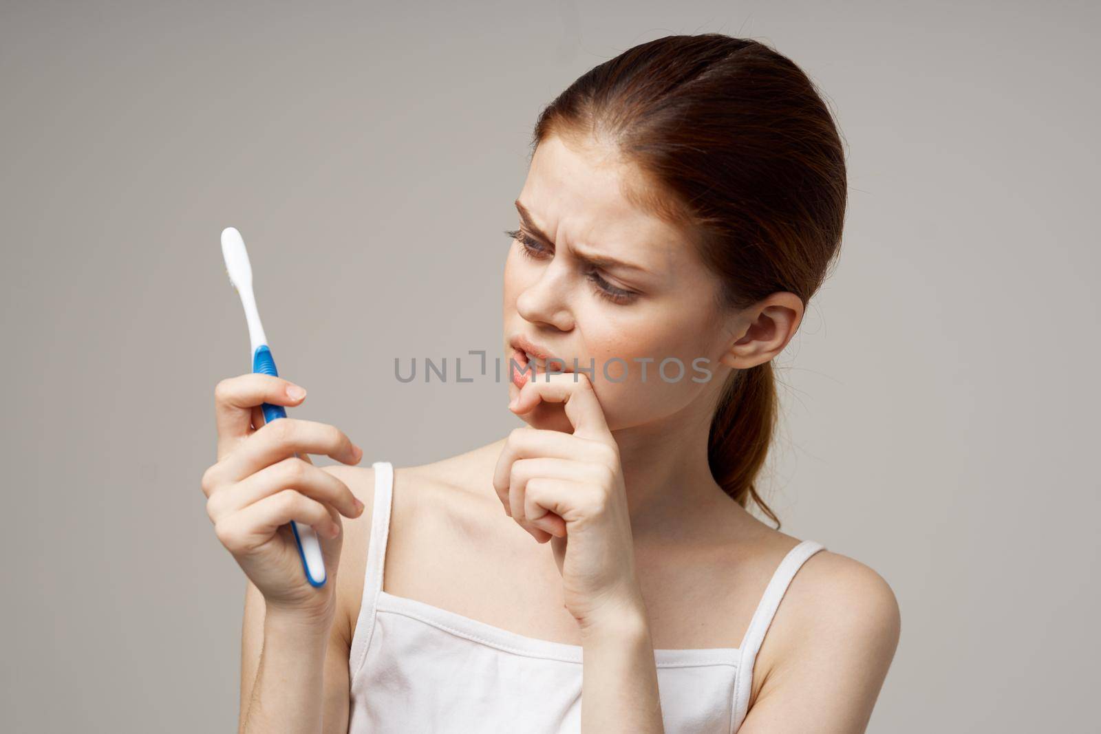 woman with a toothbrush in hand morning hygiene studio lifestyle by SHOTPRIME
