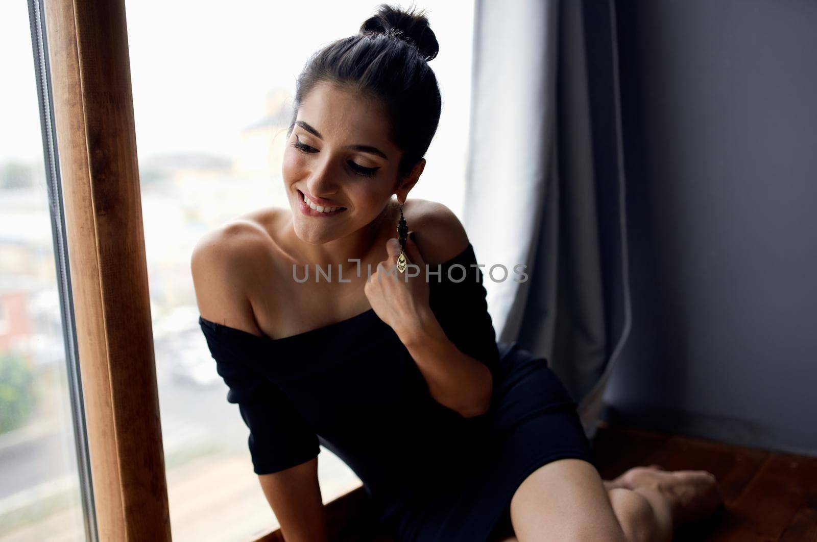 pretty woman in a black dress near the window posing lifestyle studio. High quality photo