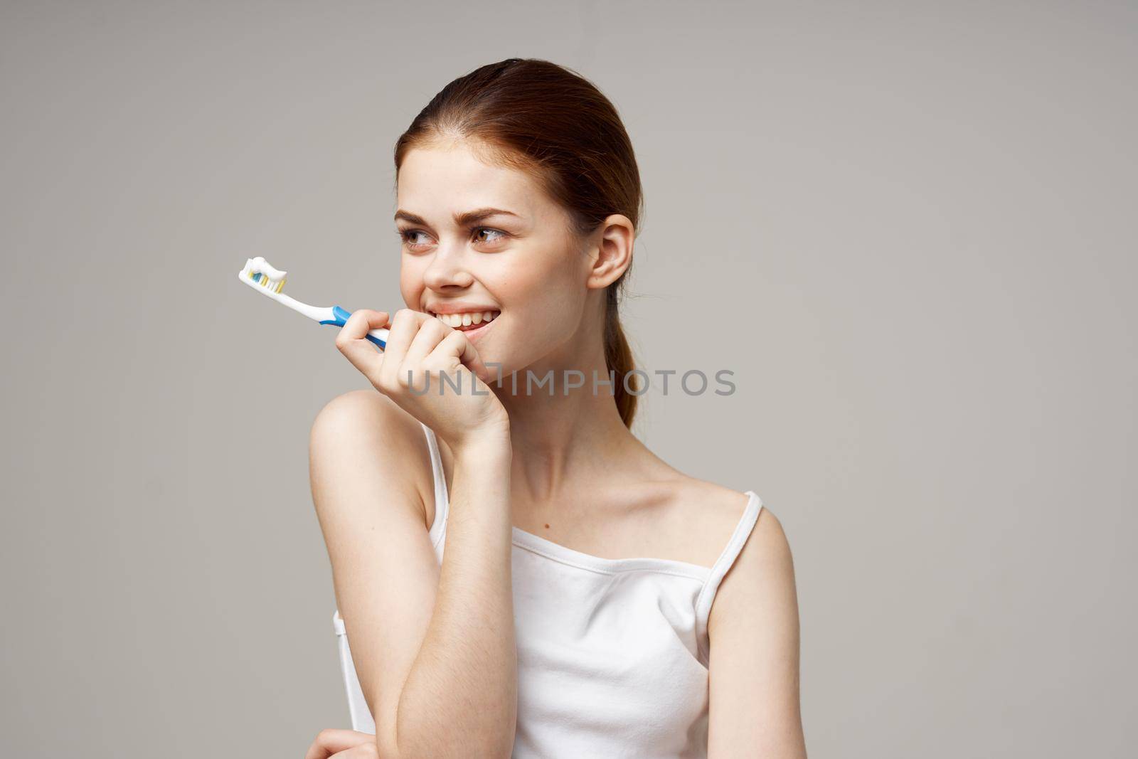 woman in white t-shirt dental hygiene health care light background. High quality photo