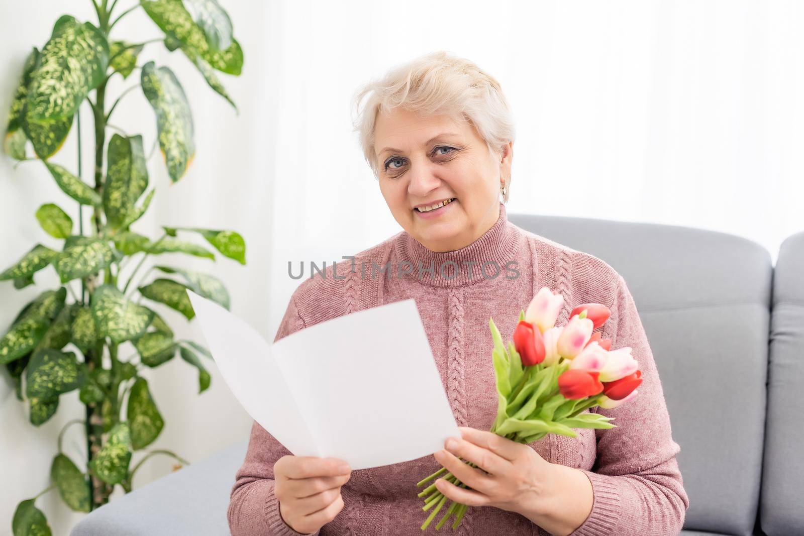 Grandmother holding bouquet of flowers, smiling.