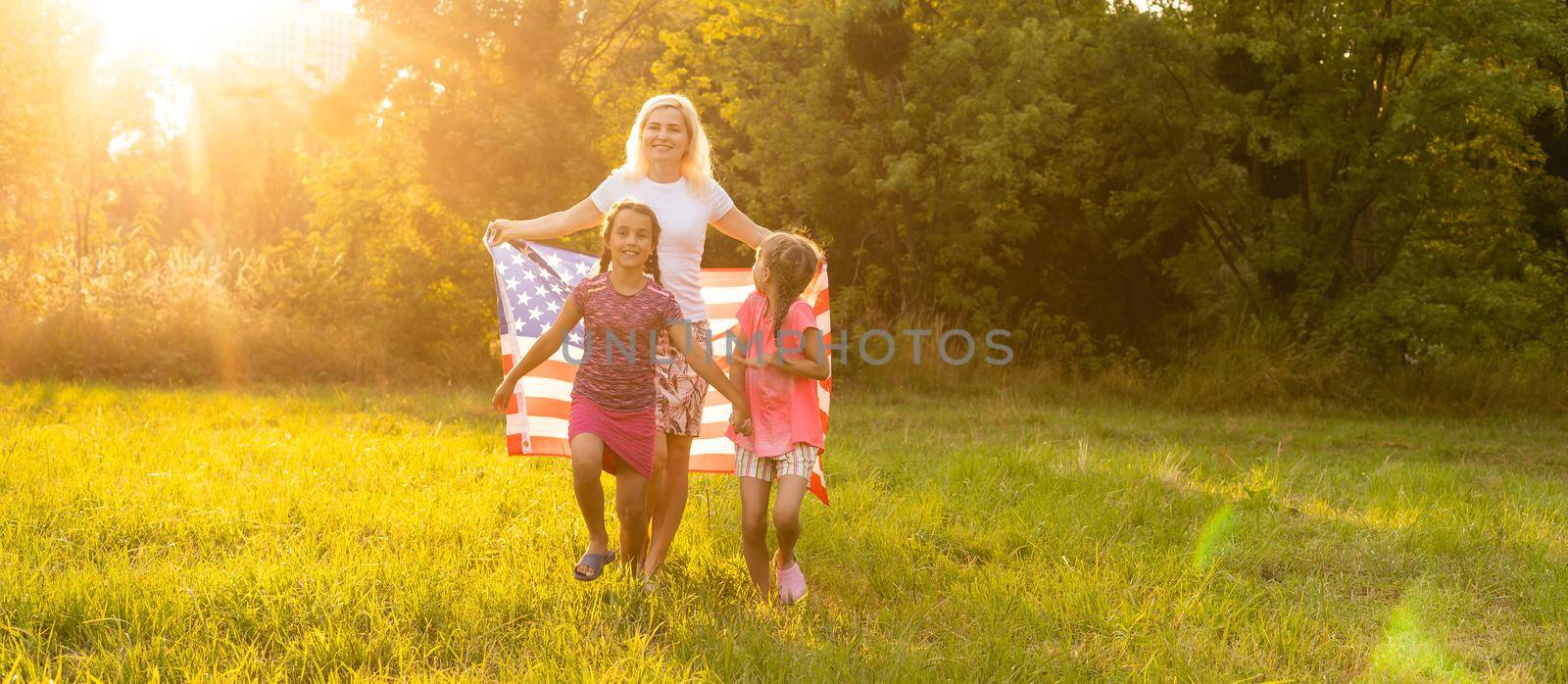 Happy family in field with USA, american flag on back