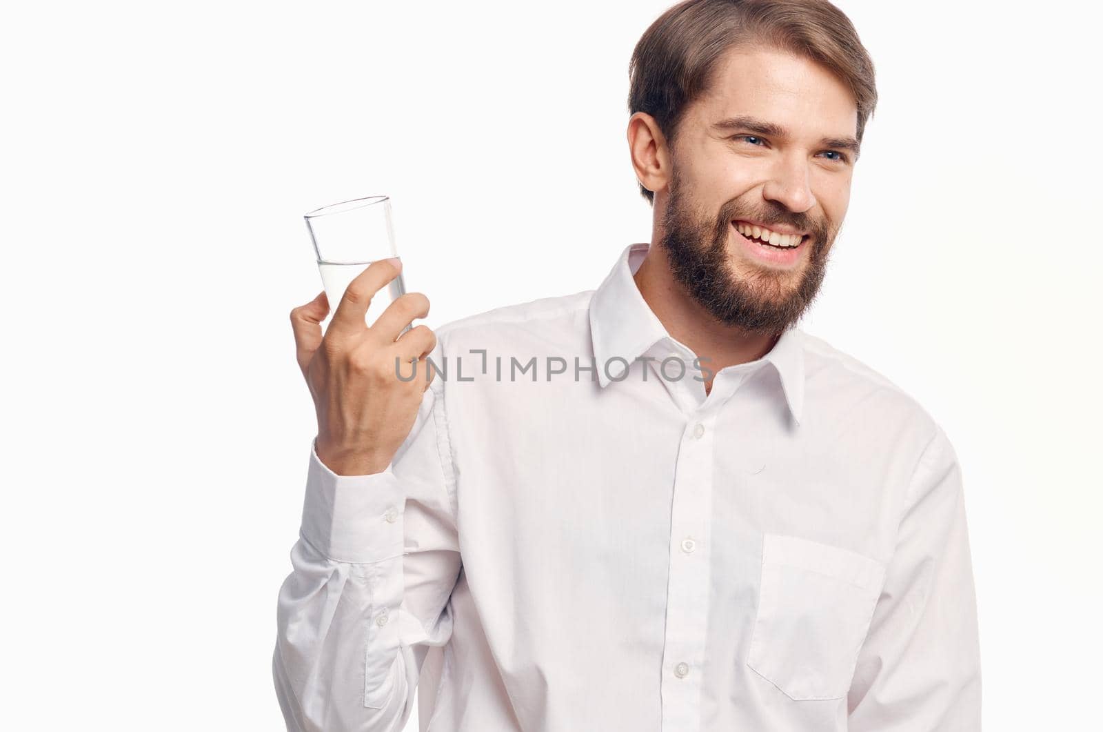 handsome man drinking water light background. High quality photo