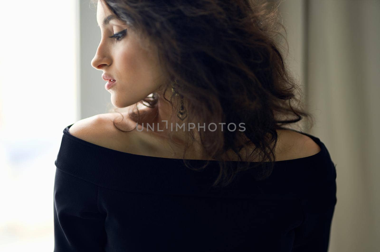 Woman in black dress near window posing fashion luxury. High quality photo