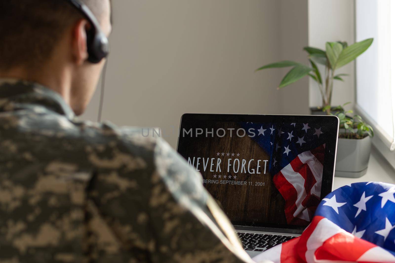 Soldier working with laptop in headquarters building.