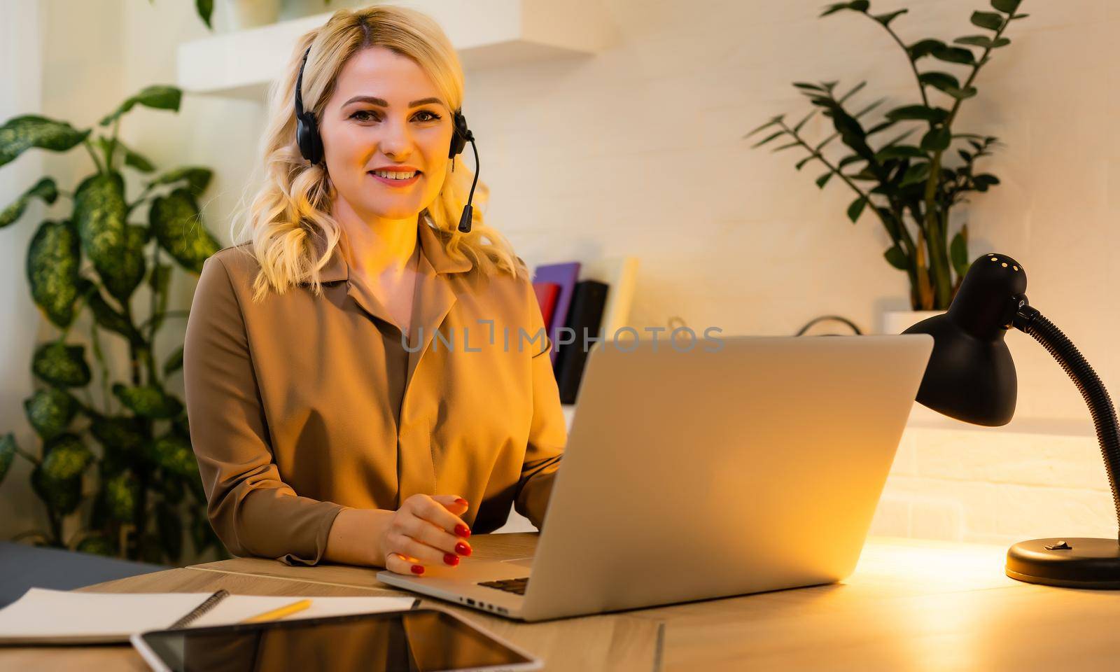 A happy woman girl works remotely from home and communicates via video call with friends and relatives in her office. Distance learning and work online. Using computer.